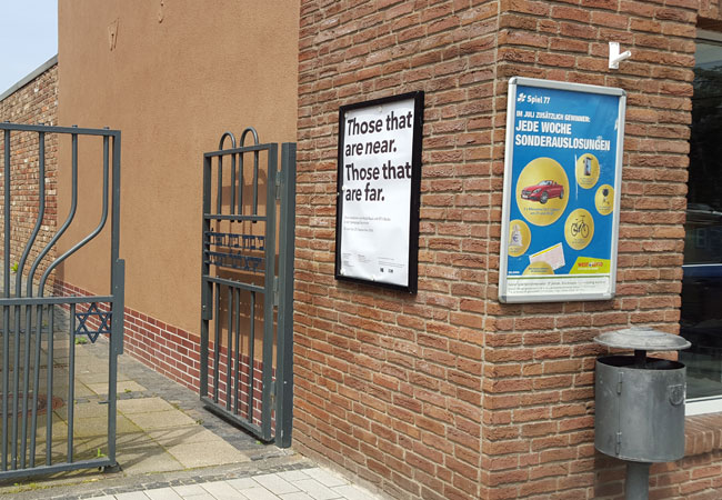 Abgrund im Alltag: Neben der Werbung für die Lotto-Sonderauslosungen weist das Plakat über dem Tor zur Synagoge mit dem siebenarmigen Leuchter den Weg zur Installation von Walid Ra‘ad.