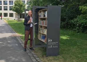 Prof. Birgitta Wolff spendet den "ersten Meter" Bücher zur Einweihung des Bücherschranks auf dem Campus Westend