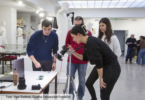 Vier Studierende fotografieren eine Vase.
