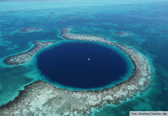 Drohnenaufnahme aus 200 Metern Höhe auf das „Great Blue Hole“ mit der in der Mitte verankerten Bohrplattform. Im Hintergrund ist der Rand des Lighthouse Reef-Atolls zu sehen. Foto: Eberhard Gischler