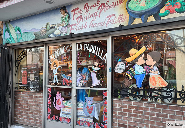 Küssen und Essen hängen offenbar zusammen: Außenwerbung für das Restaurant La Parilla in Boyle Heights, Los Angeles, aufgenommen 2021. © Whittaker